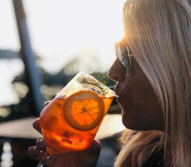 Owner Amy sipping a Spritz cocktail