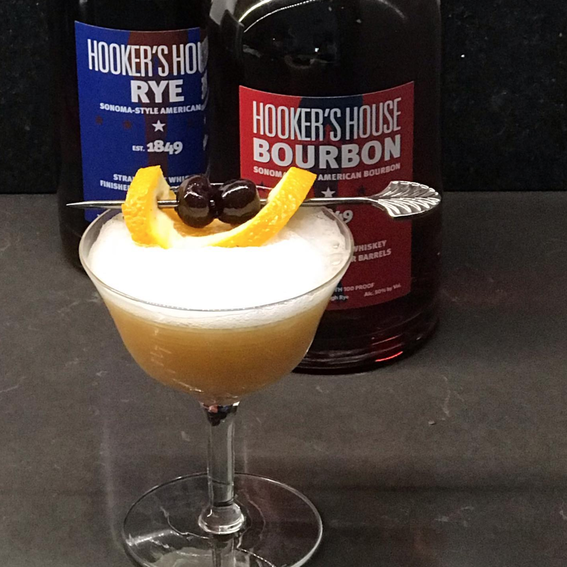 Whiskey sour cocktail with whiskey bottles